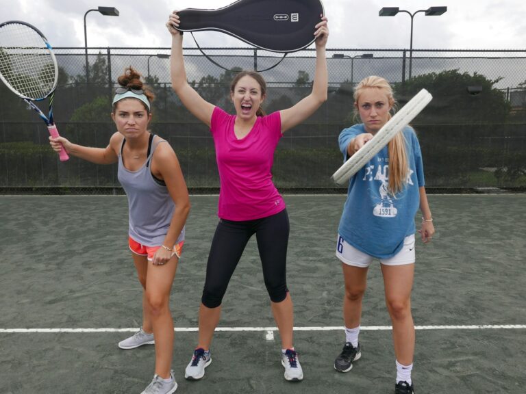 Three players celebrating with their rackets